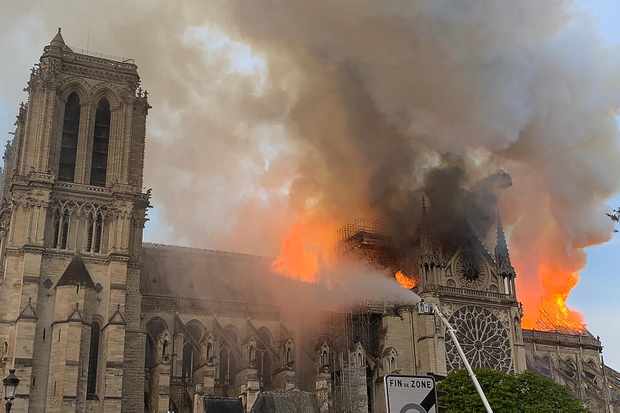 Flames and smoke are seen billowing from the roof at Notre-Dame Cathedral in Paris on April 15, 2019. - A fire broke out at the landmark Notre-Dame Cathedral in central Paris, potentially involving renovation works being carried out at the site, the fire service said.Images posted on social media showed flames and huge clouds of smoke billowing above the roof of the gothic cathedral, the most visited historic monument in Europe. (Photo by Patrick ANIDJAR / AFP) (Photo credit should read PATRICK ANIDJAR/AFP/Getty Images)