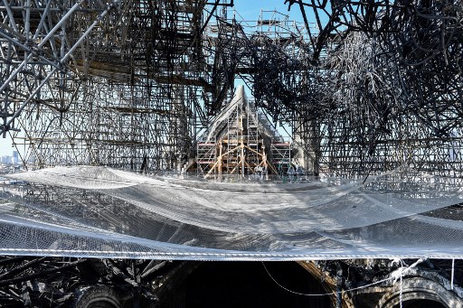 (FILES) In this file photo taken on July 17, 2019 parts of a destroyed ribbed vault and scaffolding are seen during preliminary work in the Notre-Dame de Paris Cathedral three months after a major fire in Paris. - Paris officials moved on August 6, 2019 to downplay the risk of lead poisoning from the massive fire that tore through Notre-Dame cathedral in April, as tests continue to show worrying levels of the toxic metal at nearby schools. Hundreds of tonnes of lead in the roof and steeple melted during the April 15 blaze, which nearly destroyed the gothic masterpiece, releasing lead particles that later settled on surrounding streets and buildings. (Photo by STEPHANE DE SAKUTIN / AFP)